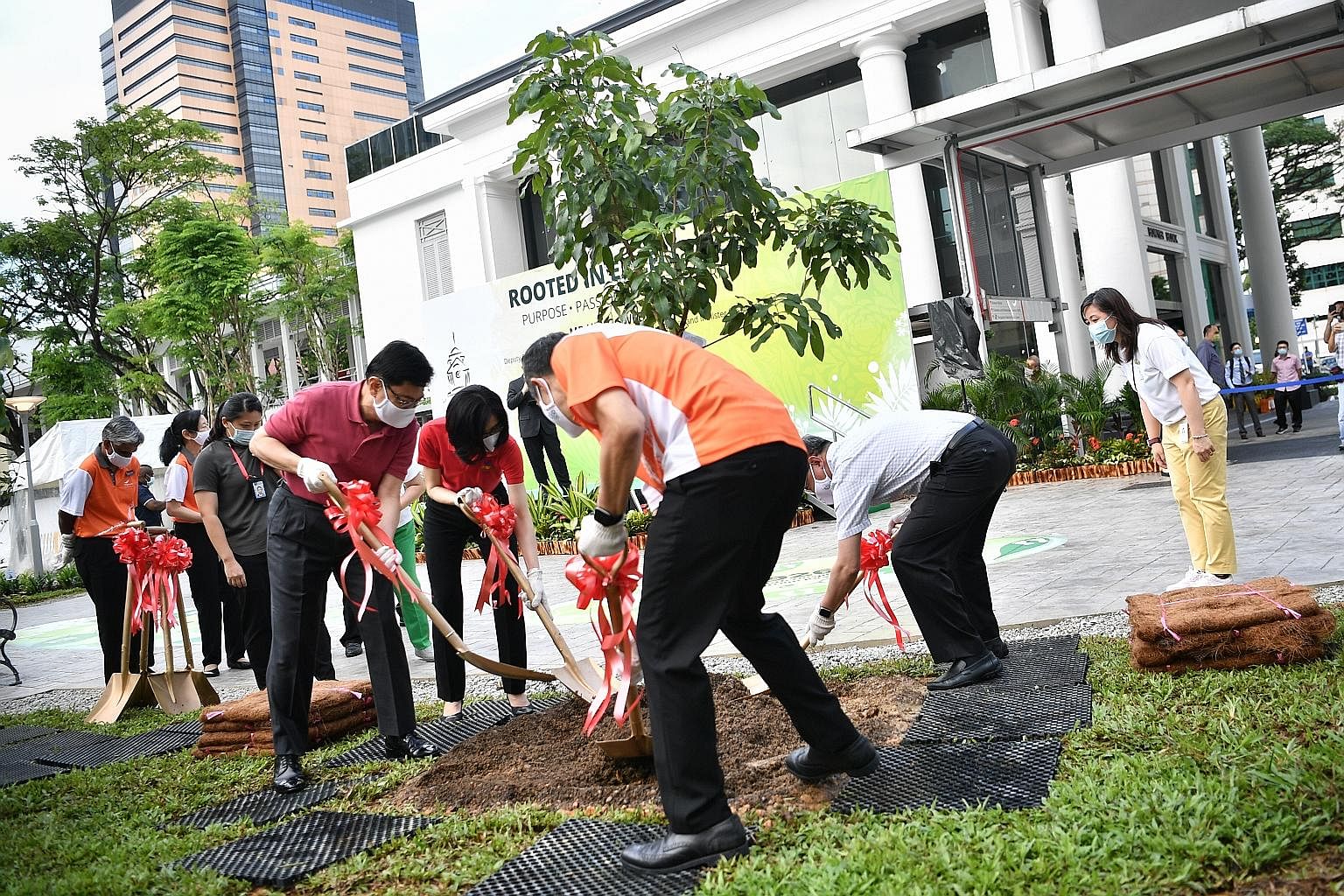 (Clockwise from far left) Deputy Prime Minister, Heng Swee Keat and Mrs Heng, as well as Health Minister Gan Kim Yong and Singapore General Hospital chief executive Kenneth Kwek, planting a longan tree yesterday at the hospital's new garden as it mar