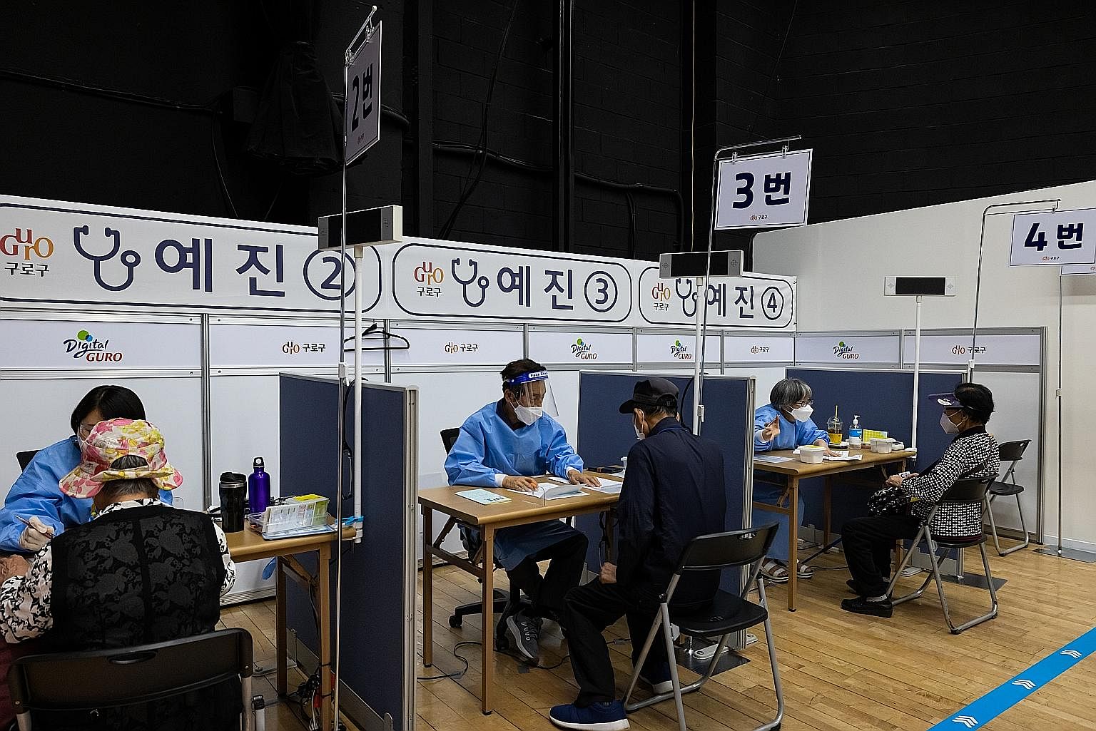 Des résidents âgés s'entretiennent avec des médecins avant de recevoir une dose du vaccin Pfizer-BioNTech Covid-19 sur un site de vaccination au Guro Arts Valley Theatre dans le district de Guro à Séoul.  Seulement 4,5 % de la population sud-coréenne, soit 2,32 millions de personnes,