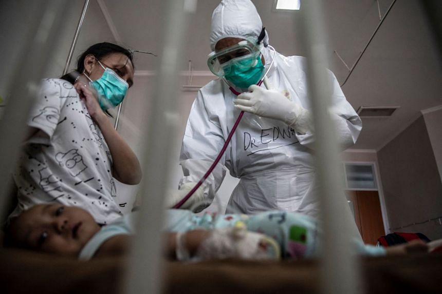 A doctor tends to a baby who tested positive for Covid-19 at a hospital in Bogor, Indonesia, on June 23, 2021.
