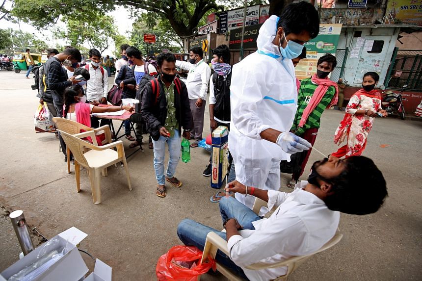 A health worker takes a nasal swab sample of a man at the City Railway station in Bangalore, on Aug 2, 2021.