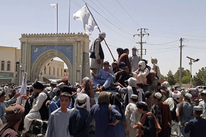 Taleban fighters stand on a vehicle along the roadside in Kandahar on Aug 13, 2021.