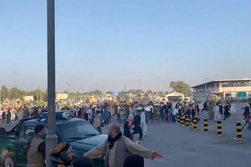 People run towards the Kabul Airport Terminal, after Taliban insurgents took control of the presidential palace in Kabul on Aug 16, 2021.