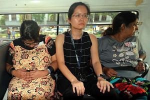 A CID officer sits between Gaiyathiri Murugayan (left) and her mother Prema Naraynasamy, who were charged in court on Thursday (July 28) with murdering their Myanmar domestic worker at their home in Bishan earlier this week.