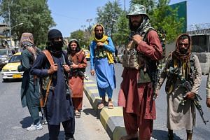 Taleban fighters stand guard along a street near the Zanbaq Square in Kabul on Aug 16, 2021.