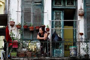A woman looking out from the balcony of her home in Hanoi, during the government-imposed lockdown, on Sept 4, 2021.