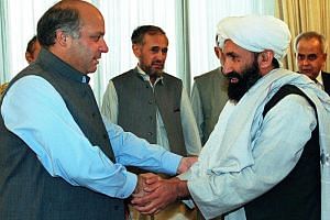 In this Aug 26, 1999, file photo, Pakistani Prime Minister Nawaz Sharif receives Afghan Foreign Minister, Mullah Hassan Akhund (right), in Islamabad. 