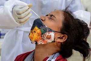 A medical worker takes a swab sample from a woman during a Covid-19 coronavirus screening in Mumbai, India.