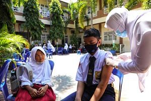 A student getting a dose of the Sinovac Covid-19 vaccine at a school in Lhokseumawe, Indonesia's Aceh province, on Oct 4, 2021.
