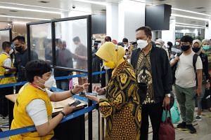 Plane passengers are checked by health workers shortly after their arrival at Jakarta's international airport.