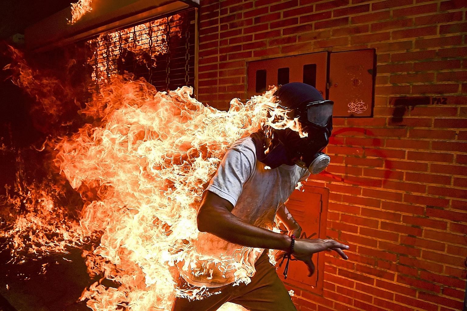 Protester Jose Victor Salazar Balza on fire amid violent clashes with riot police in Caracas, Venezuela, in May last year. The image, taken by Venezuelan photographer Ronaldo Schemidt, was named World Press Photo of the Year.